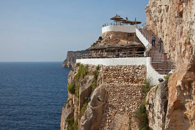 Cova d'en Xoroi built into the cliffside with stairs down