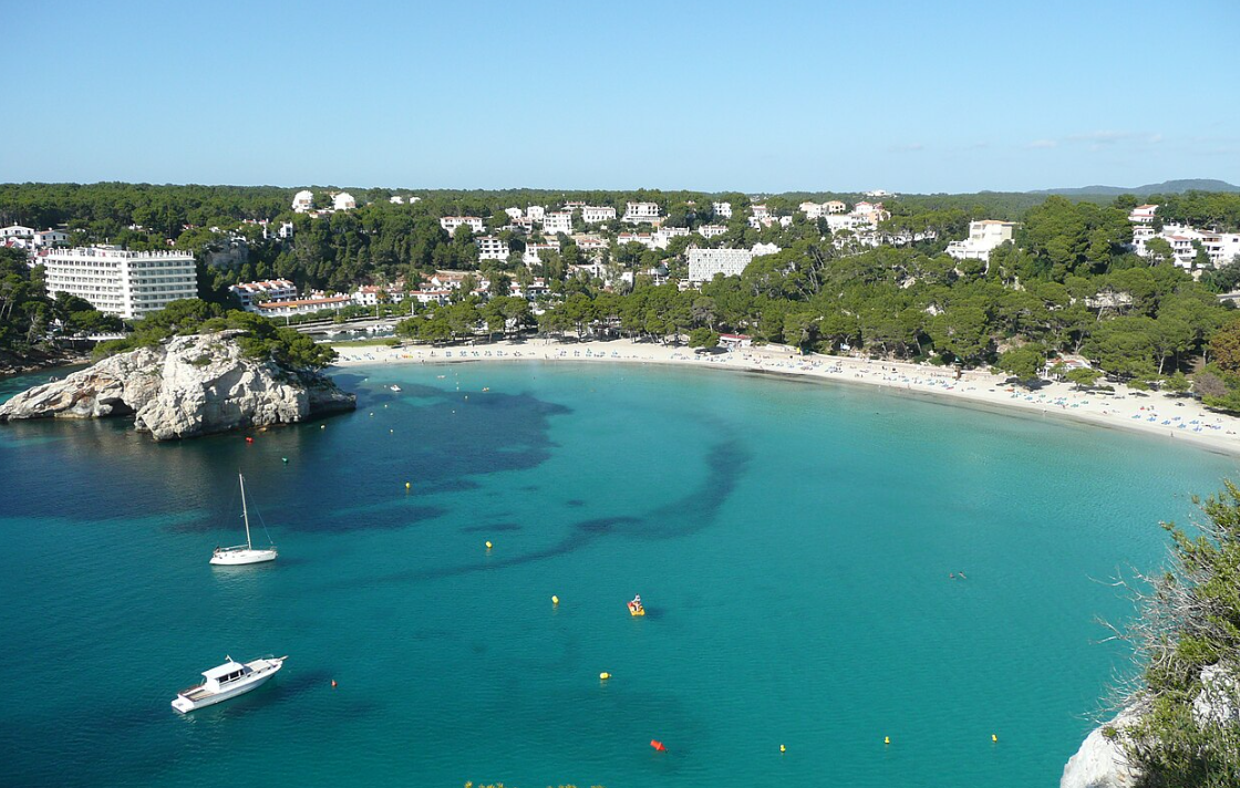 Aerial view of Cala Galdana bay's turquoise water and sandy beach