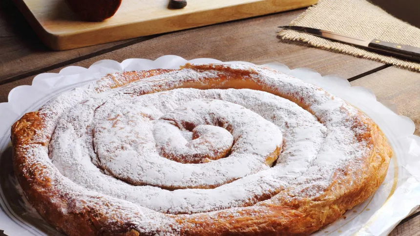 A whole ensaimada dusted with powdered sugar