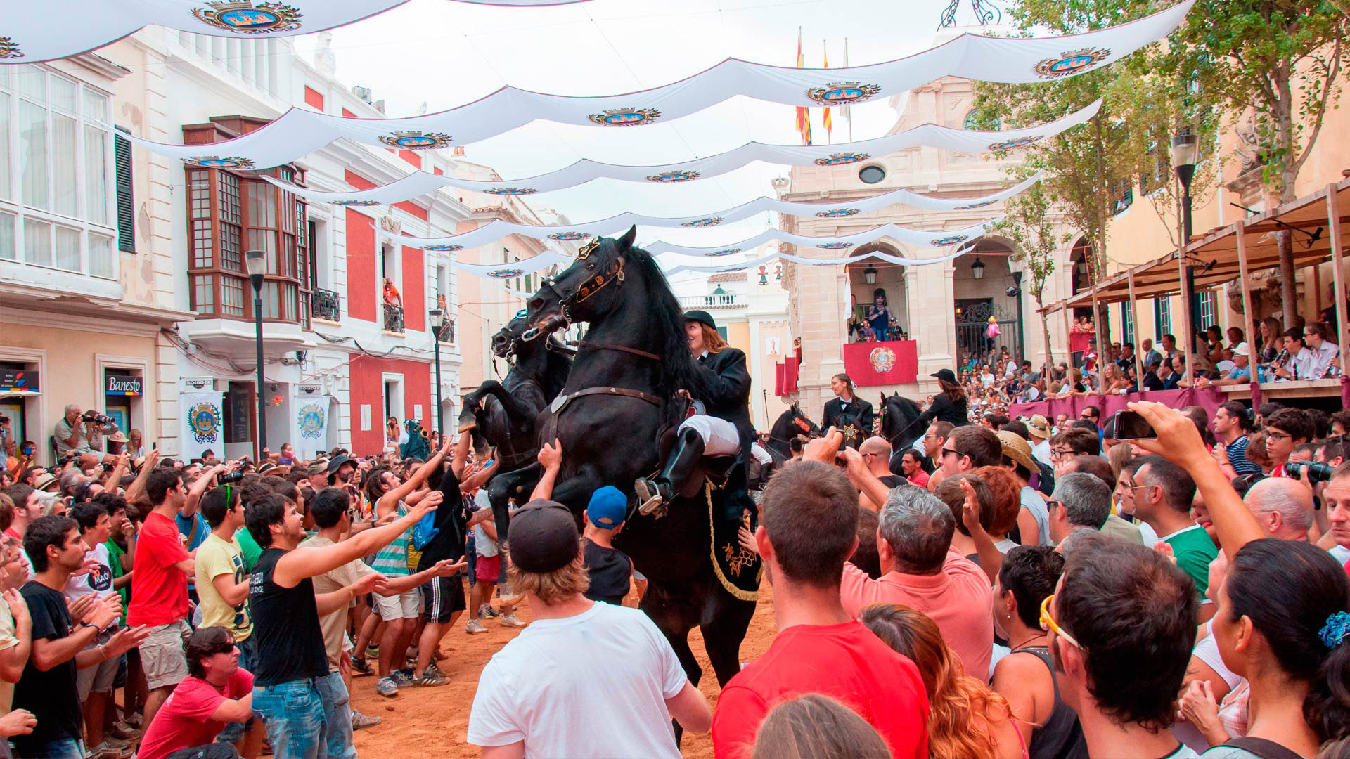 A rearing horse held up by a crowd during a Menorcan fiesta