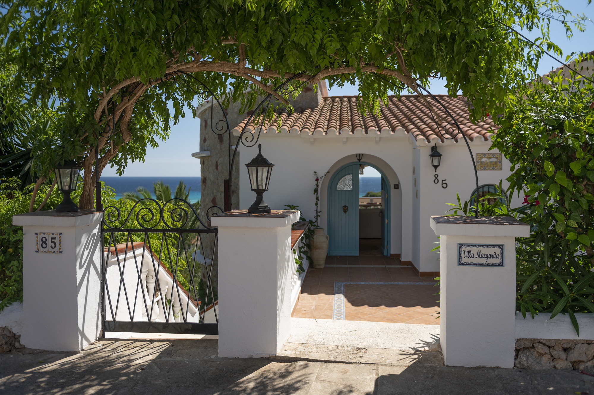 The gated entrance to Villa Margarita, sea view beyond
