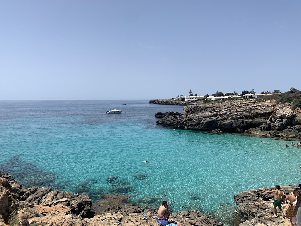 Clear turquoise cove framed by rocky cliffs