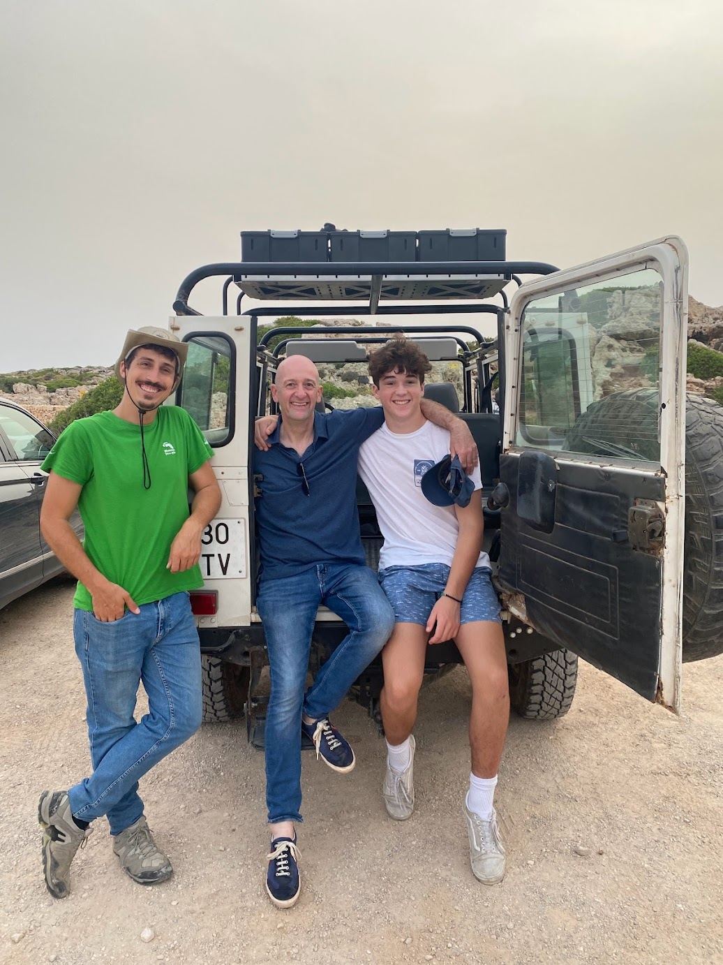Three people posing with the jeep on the Jeep Safari Menorca tour